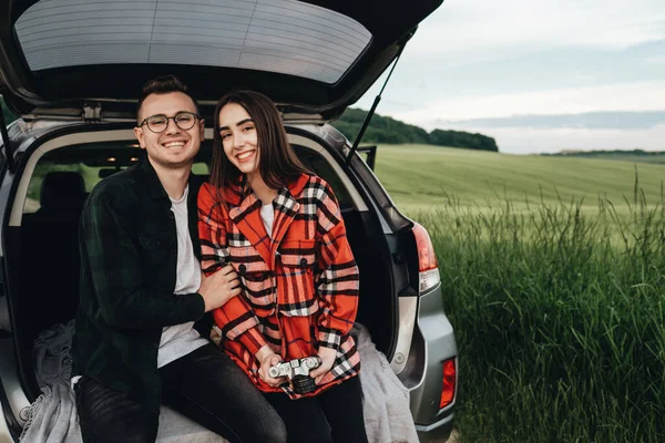 Genç Güzel Bir Çift Araba Bagajında Oturuyor Yolculuğun Tadını Çıkarıyor — Stok fotoğraf