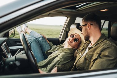 Man and Woman Sitting Inside Car, Having Fun and Enjoying Adventure Road Trip clipart