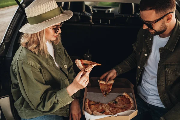 男人和女人坐在汽车里吃比萨 — 图库照片