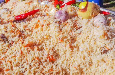 Özbek pilavı pazarında. Pilav et, sarımsak, biber ile açık bir yangın. Pilav ile büyük tava. Zam, açık hava etkinlikleri pişirme turist Melon gıda ile.