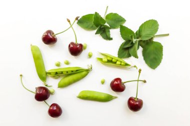 Kırmızı taze kiraz, yeşil bezelye, beyaz arka planda nane. Çiftçi pazarı taze organik meyve.