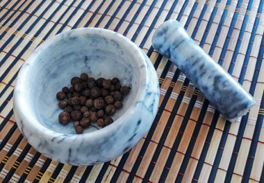 Masada havan var. Biber tohumları harç içine. Ahşap arka planda karabiber yakın çekim görüntüsü. Yukarıda görüntüle.