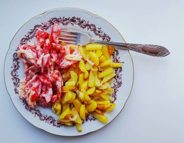 Tabak içinde soğan ile patates kızartması.