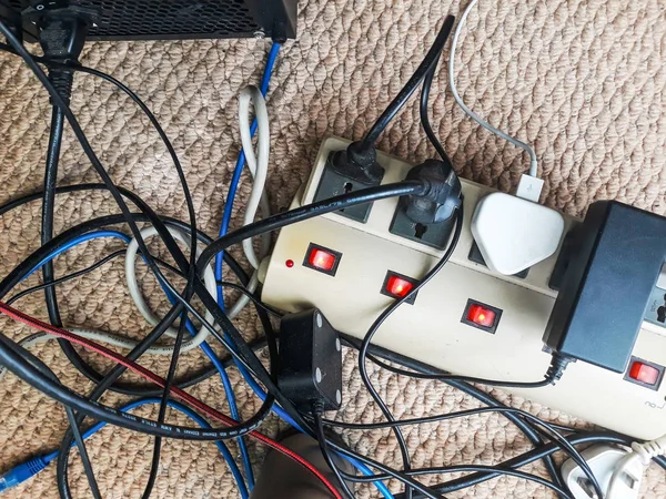 Elektrik kablosu. Aşırı yüklenmiş güç panoları. Bir güç kartlarına bağlı birçok elektrik kablosu. Zemin işyerinde karışık bir karmaşa içinde kablo güç kabloları.