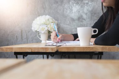 kahve dükkanında kitap kadın el ve mavi kalem üzerinde yazma