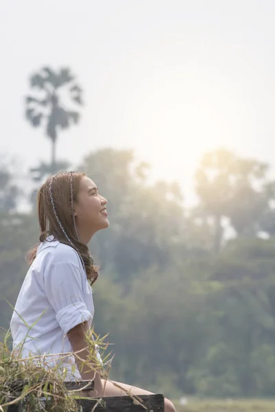 Mutlu kadın kırsal sonbahar ormanda neşeli gülümseyen üzerinde oturuyordu