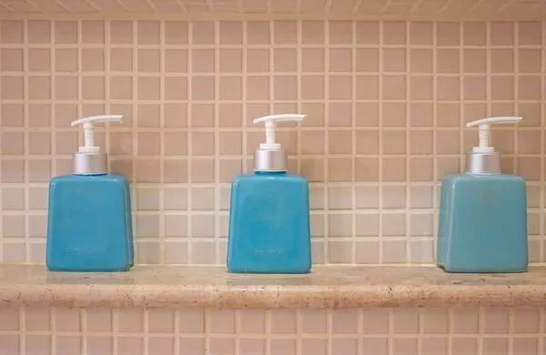 liquid soap and shampoo bottle on the shelf in the bathroom