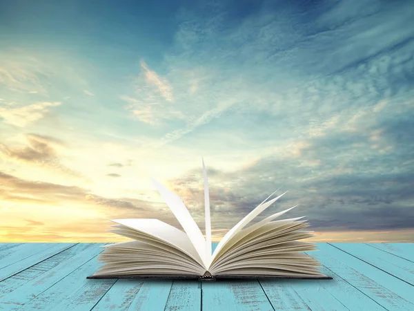Akşam gökyüzü arka plan ile tablo açık kitap