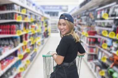 Alışveriş merkezinde alışveriş sepeti iterek Genç Asyalı kadın