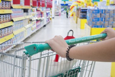 Alışveriş merkezinde alışveriş sepeti iterek kadın el