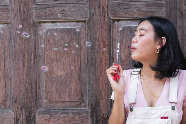 Giovane felice donna asiatica facendo bolle di sapone — Foto Stock