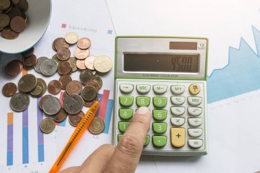 Gelir ve sonucu saymak için hesap makinesi kullanan erkek el