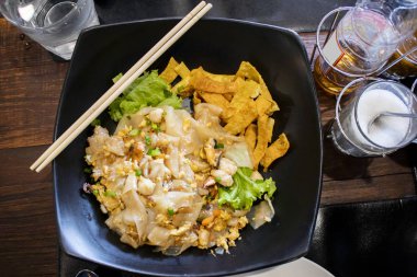 Yakın tavada kızarmış taze pirinç yağlı erişte karıştırın