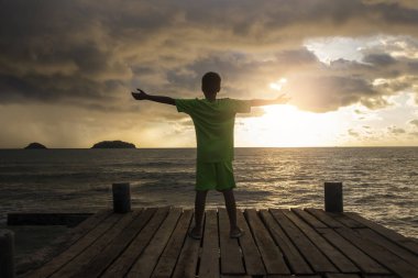 çocuk gün batımı gökyüzünde eller yukarı ahşap yürüyüş üzerinde stand