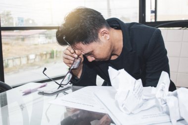 Genç Asyalı iş adamı parlak baskı üzerinde çalışıyor