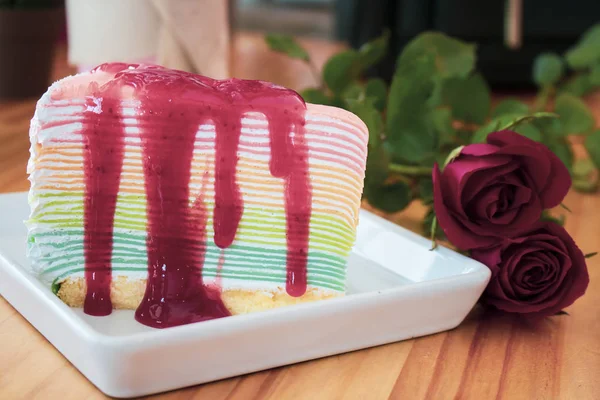 Crepe cake with strawberry sauce on table