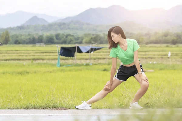 Giovane atleta femminile che esercita e si estende in un parco prima — Foto Stock