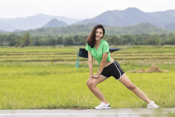 Jeune athlète féminine faisant de l'exercice et s'étirant dans un parc avant — Photo
