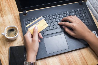 Asya genç kadın eller Holding kredi kartı ve kullanarak laptop