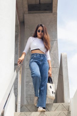 Güneş gözlüğü takan güzel Asyalı genç bir kızın açık hava portresi.