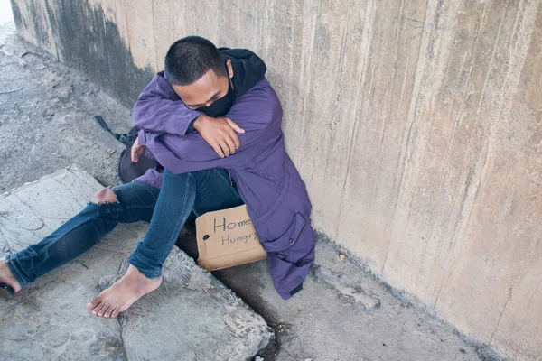 Unhappy homeless man under the bridge