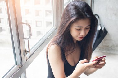 Kafede telefon kullanan mutlu Asyalı kadınlar.