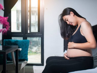 Evde, yatak odasında mutlu hamilelikler.