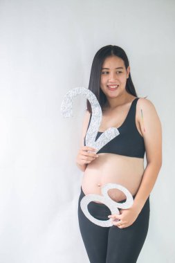 Beyaz arka planda duran gülümseyen hamile kadın. 28 haftalık hamile.