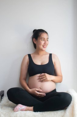 Evde oturan hamile kadının portresi.