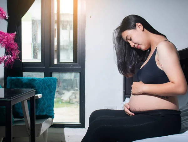 Evde, yatak odasında mutlu hamilelikler.