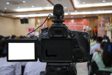 Video kaydedicinin arka görüntüsü bulanık seyirci ve konuşmacı arkaplan ile canlı olay kaydediyor