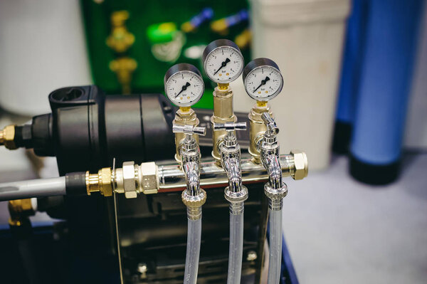 Thermometer, pipes and faucet valves of heating system in a boiler room.