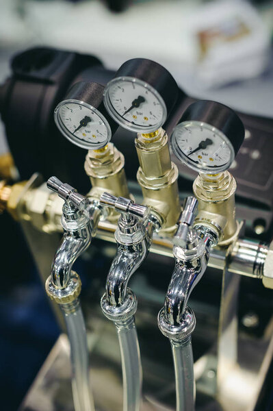 Thermometer, pipes and faucet valves of heating system in a boiler room.