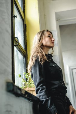 Siyah kot giyim, kot pantolon ve gömlek, eski püskü bir konumda bir kadında