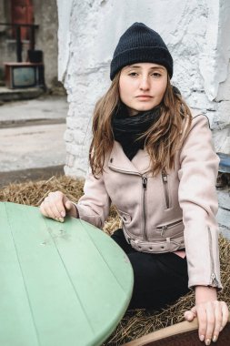 Siyah kot pantolon, şapka ve pembe bir ceket, bir harap kentsel çatı konum kadın. Güzellik moda ve stil