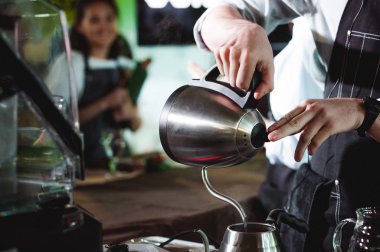 şampiyonluk arasında kahvehane, içecekler, ekip çalışması hazırlamak barista'nın Beceri, takım üyeleri gösterir. dökülen su bir su ısıtıcısı