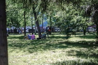 çimenlerin üzerinde parkta dinlenin. çift dinlenme, çim üzerinde oturan, bisiklet ile