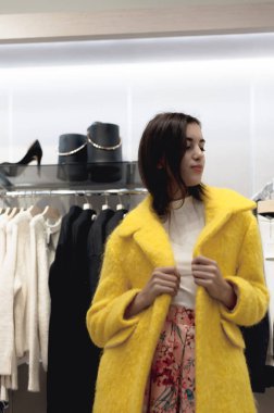 Genç güzel duygusal modern kadın alışveriş merkezi üzerinden yürür, moda giyim mağazaları işlere bakar