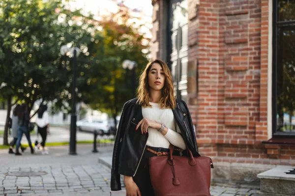 portrait of a young beautiful woman on street, model posing, women\'s urban street fashion, warm colors