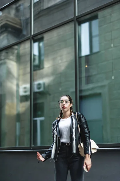 portrait of a young beautiful woman on street, model posing, women's urban street fashion