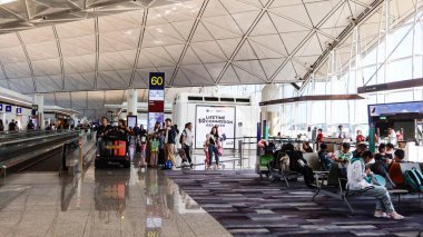 Chek Lap Kok, Hong Kong Uluslararası Havaalanı, Hong Kong - 13 Ağustos 2025: Yolcular kapı kolunda fotoğraf çekiyorlar ve biniş için bekliyorlar