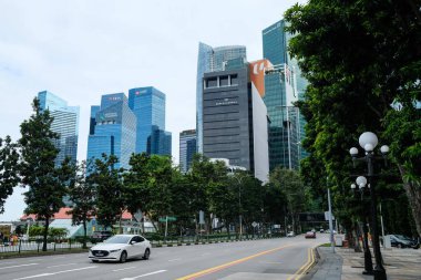 Marina Körfezi, Singapur 13 Ağustos 2025 Singapur şehri her iki tarafında yemyeşil ağaçlar ve arka tarafında gökdelenler olan bir arabayı gösteriyor.