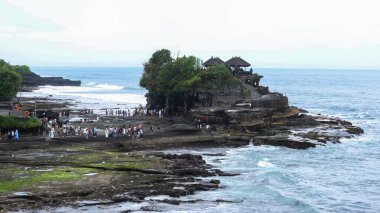 Tanah Lot, Beraban, Kediri, Tabanan Regency, Bali, Endonezya - 18 Ağustos 2025: Antik Hindu hac tapınağı Pura Tanah Lot 'un sahil kıyısında birçok turistle birlikte inşa edilmiş geniş bir görüntüsü