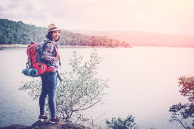 Mutlu Asyalı kadın tatil gezisi konseptinde dinleniyor, seçici ve yumuşak odaklı, yenilikçi tarzında.