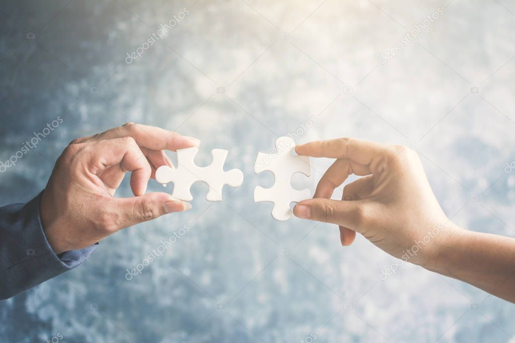 Business people holding jigsaw connection and success concept