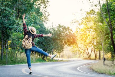 Asyalı kadın sırt çantası yolda ve orman arka plan, yolculuk ve seyahat eden konsept tatil .