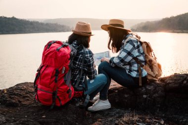 Asyalı kadınlar park yolculuk ve tatil kavramı üzerinde seyahat sırt çantası.