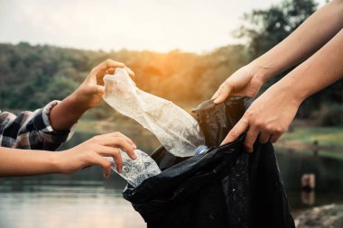 Gönüllü nehirde bir şişe plastik alarak, bir su kirliliği kavramı çevreyi korumak.