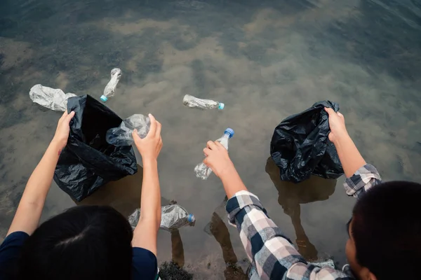 Wolontariusz Zbierając Plastikową Butelkę Rzece Chroniąc Środowisko Przed Zanieczyszczeniem Wody — Zdjęcie stockowe