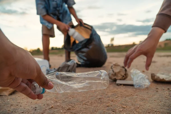 The volunteer picking up a bottle plastic , protect environment concept.
